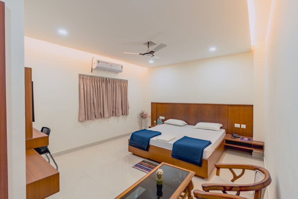 Spacious hotel room in Kendrapara with twin beds, wooden furnishings, and modern amenities